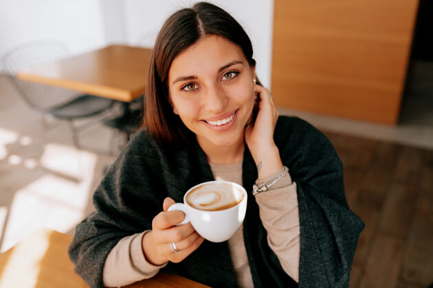 优雅坐在咖啡馆里喝咖啡的女人水平快乐斗篷