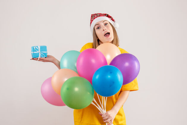 乐趣手持小礼物和白色气球的年轻女性举行聚会情感