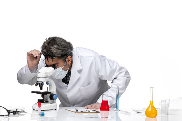 人前视图中年科学家穿着特殊的白色西装使用显微镜专业工作特殊