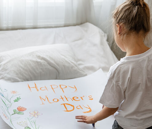 人物小女孩给妈妈画贺卡 上面写着母亲节快乐和鲜花文字绘画绘画