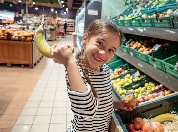 小超市里拿香蕉的有趣的小女孩女孩室内儿童