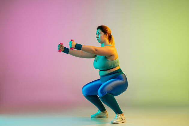人年轻白种人加上大小女模特训练梯度紫绿色墙运动员健身哑铃