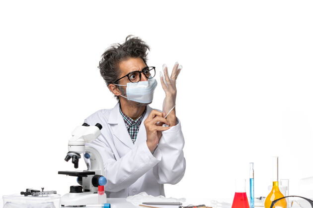 前面正面图中年科学家戴着手套戴着口罩穿着特殊的西装实验室实验技术员