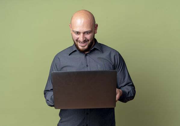 绿色印象深刻的年轻秃头呼叫中心男子举行 看着笔记本电脑孤立的橄榄绿与复制空间人持有年轻