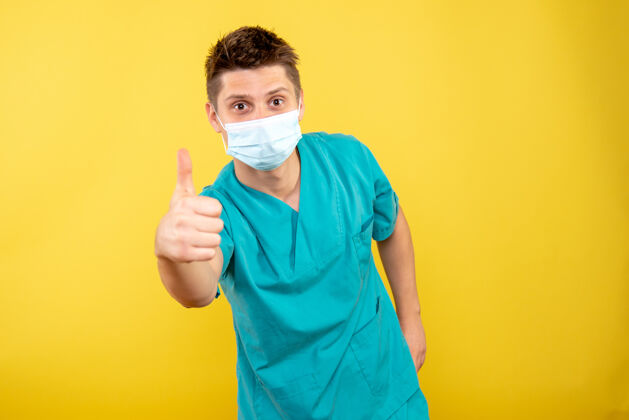健康正面图身着医疗服的年轻男医生 黄色背景上有无菌面罩肖像人物绝育