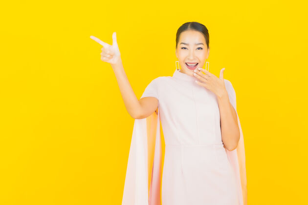 化妆画像美丽的亚洲年轻女子微笑着在黄色的墙上有许多动作成功中国人表情