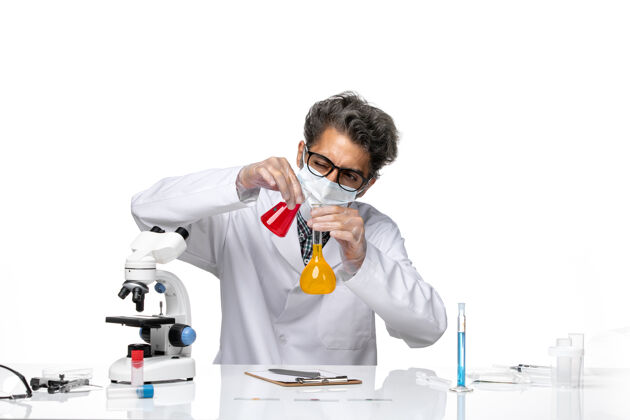 男性正面图中年科学家穿着特制的混合液套装观察实验前面