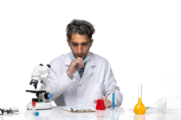 视图前视图穿着白色医疗服的中年科学家围坐在桌子旁 拿着解决方案实验室实验室外套药剂师
