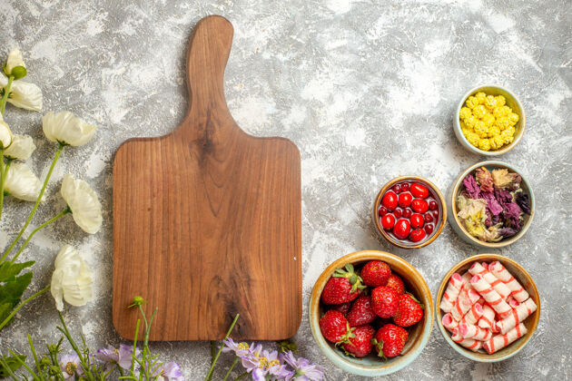 饮食顶视图新鲜的红色草莓和糖果的白色表面浆果糖果水果胡椒盘子勺子