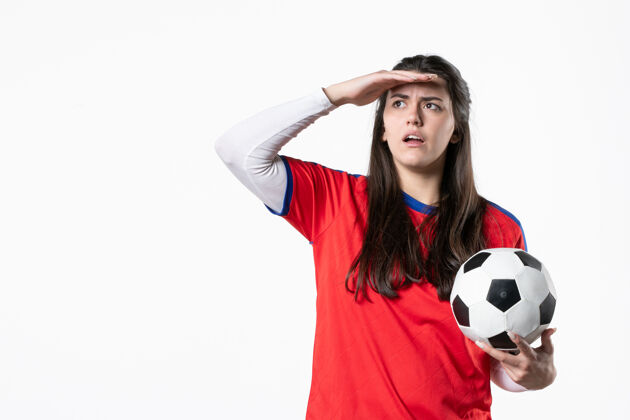 设备前视图穿着运动服的年轻女性 白色墙壁上有足球白色足球前面
