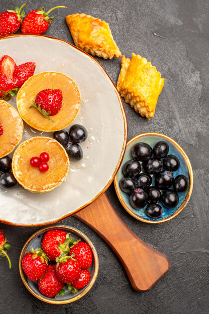 饮食俯瞰美味的薄饼与水果在黑暗的桌子上馅饼水果蛋糕甜午餐顶部橄榄