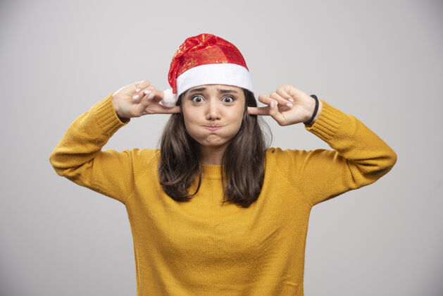 冬天戴圣诞帽的女人捂住耳朵屏住呼吸表情女性圣诞老人