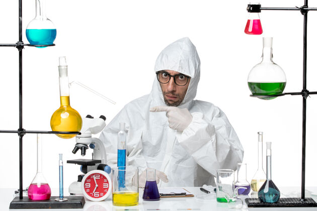 疾病正面图穿着特殊防护服的男科学家坐在那里解决问题科学实验实验室外套