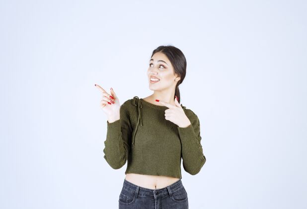 目录一个年轻的女模特站在一边用食指指着照片手指女人手指