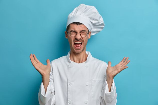 姿势忙得情绪化的厨师举手大喊 在厨房工作多 戴着圆眼镜 穿白色制服 和厨师吵架服务爱好男人