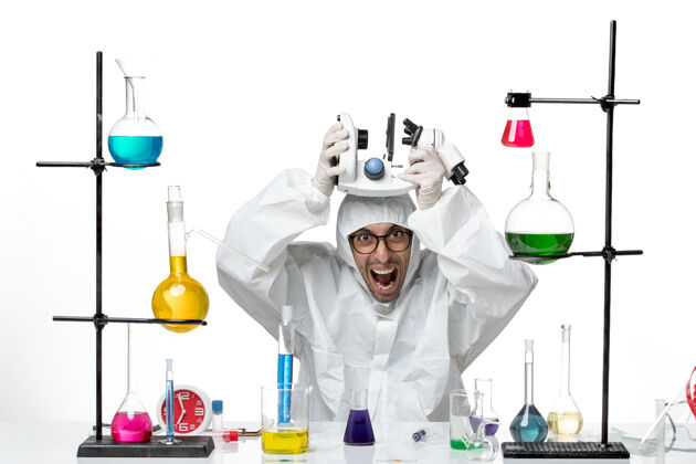 实验室正面图穿着特殊防护服手持显微镜的男科学家化学科学外套