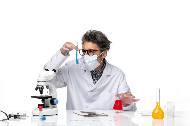 特殊正面图穿着特殊套装的中年科学家坐着拿着装有解决方案的烧瓶实验室烧瓶实验室