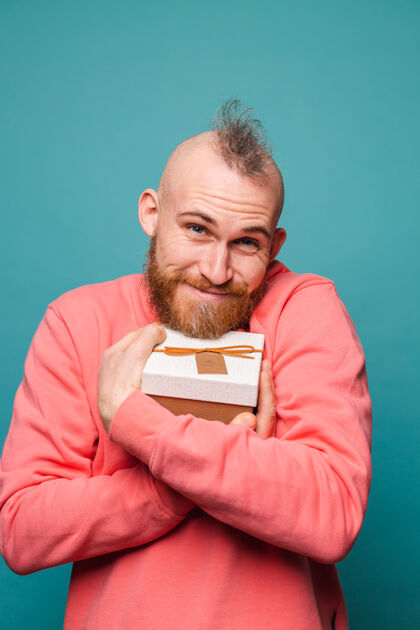 请留着胡须的欧洲男人在随意的桃色孤立 快乐的拥抱礼盒肖像男人生日礼物