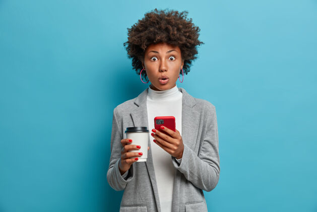 咖啡印象深刻的非洲裔美国女商人手持纸杯和智能手机的形象优雅年轻人人