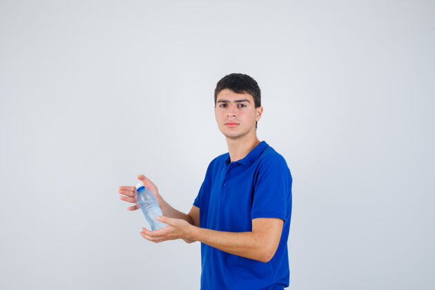 人类年轻人手里拿着一个塑料瓶 穿着t恤衫 看上去很自信 正面照人快乐年轻