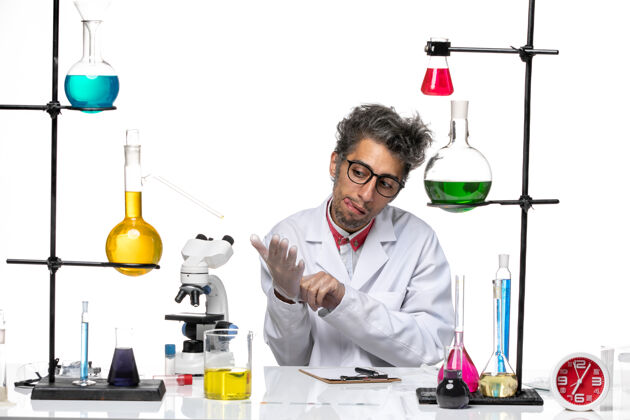 化学正面图穿着白色医疗服的中年化学家拿着溶液坐着专业实验室外套医学