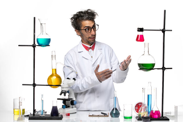 实验室正面图穿着白色医疗服的男科学家站在桌子前拿着解决方案专业人科学