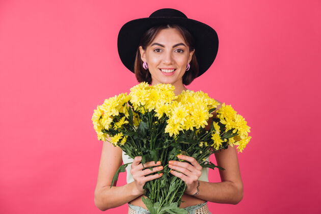 美丽漂亮时尚的女人戴着帽子摆姿势 捧着一大束黄紫苑 春意盎然 积极向上的情绪与世隔绝精品祝贺庆祝