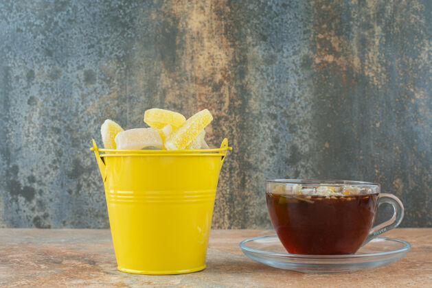 茶一个黄色的桶里装满了糖浆糖和一杯花草茶水桶果酱草药