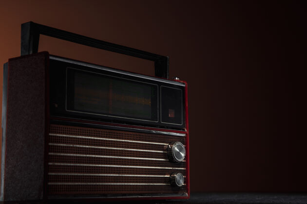 地方黑色背景上的红色收音机用复古风格的颜色和色调拍摄的复古老物件的特写镜头垃圾聚会办公室