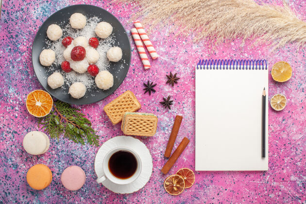 顶视图美味的椰子糖与新鲜草莓和华夫饼在粉红色表面俯瞰华夫饼美味饼干