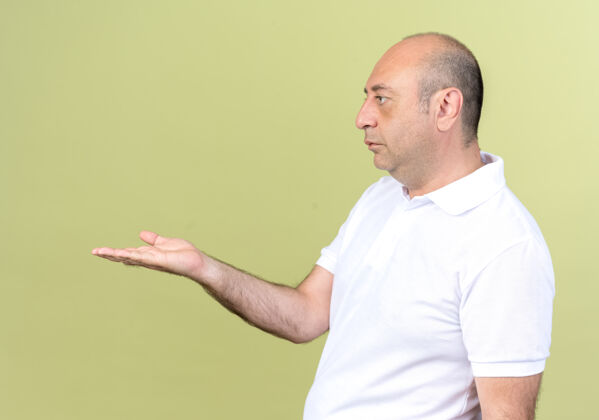 手站在侧视图中成熟的男子伸出手在橄榄绿隔离的一边观点持有立场