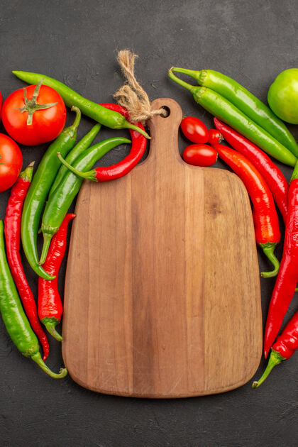 辣椒顶部近距离观看红 绿辣椒 西红柿和黑土地上的砧板烹饪健康番茄
