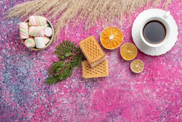 食物美味的华夫饼干俯视图 粉色表面有一杯茶和棉花糖美味水疗饼干