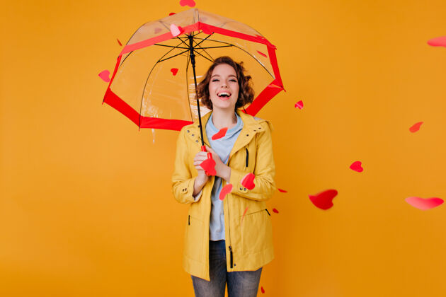 雨伞笑可爱的女孩用阳伞看着飞扬的心室内肖像优雅的卷发女士穿着黄色的衣服站在雨伞室内漂亮雨