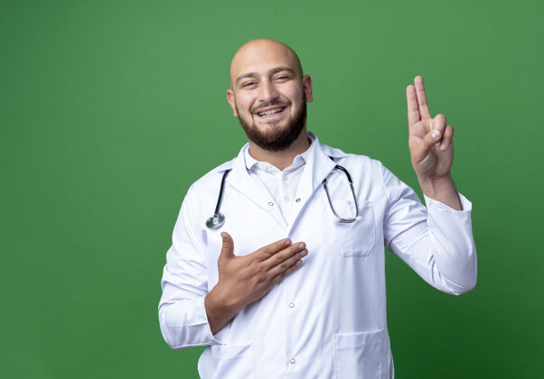 长袍微笑的年轻男医生穿着医用长袍 听诊器显示两点手二点