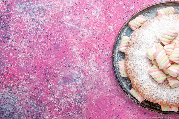 棉花糖粉红色表面上糖粉蛋糕和甜棉花糖的俯视图面团美味新鲜