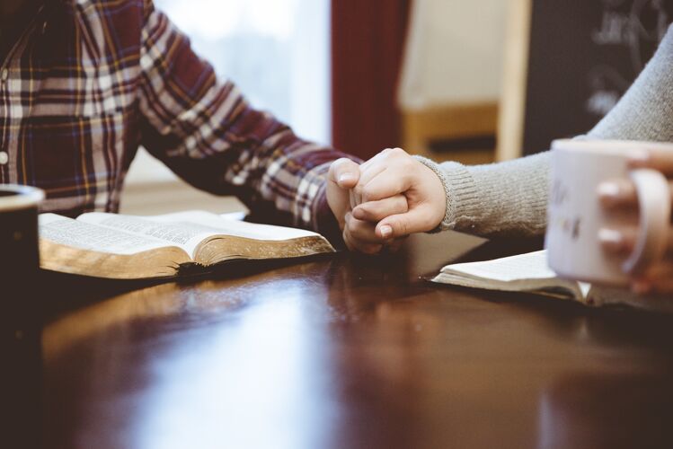 女性特写镜头：一对夫妇手把手放在桌子上看书在一起男人浪漫
