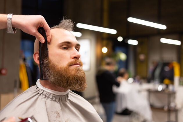 胡子在理发店剪胡子的欧洲野蛮人工作剪刀客户