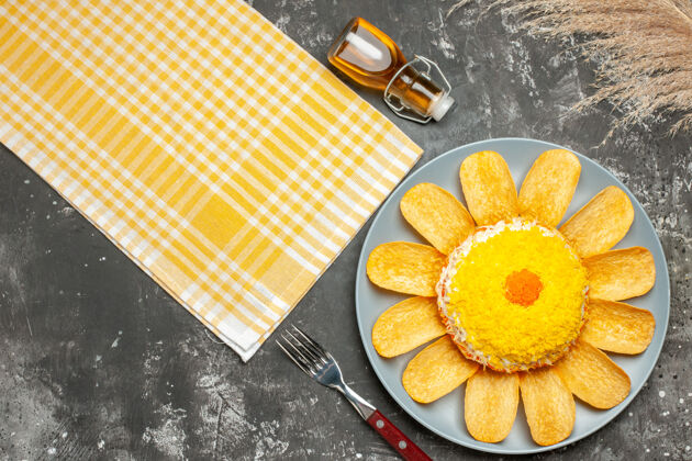 食物右侧沙拉顶视图 黄色餐巾纸油瓶叉 深灰色桌子上的小麦柑橘沙拉水果
