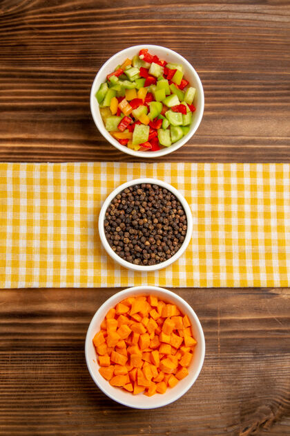 木材顶视图不同调味料的甜椒切片放在棕色木制餐桌上蔬菜餐健康沙拉晚餐蔬菜沙拉