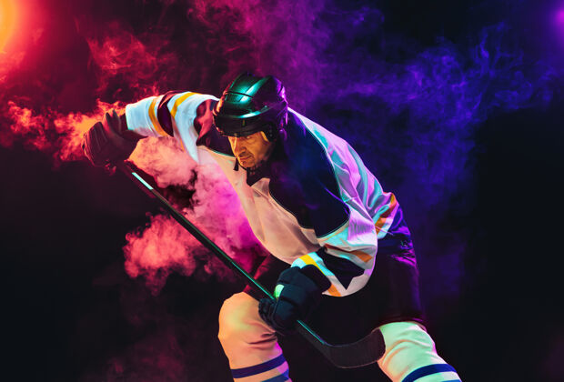 冰冰球场上的棍子和深色霓虹灯墙的男性冰球运动员运动员人动作