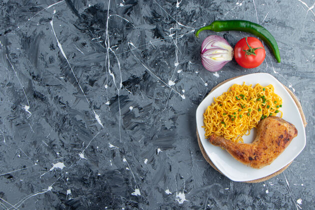蔬菜把鸡肉和面条放在盘子里 放在蔬菜旁边的三角架上 放在大理石背景上洋葱午餐胡椒粉