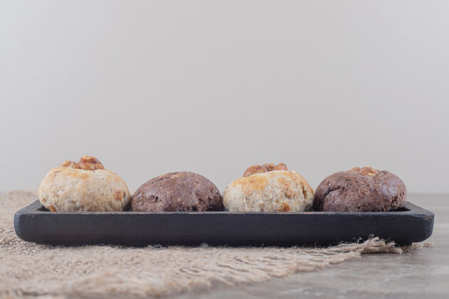 美味饼干放在大理石上的一块布上的小托盘上可口甜点口感