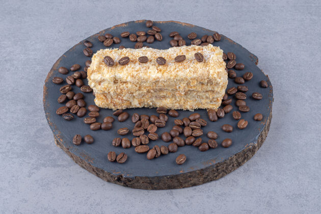 蛋糕小蛋糕和咖啡豆放在大理石的木板上烘焙食品糕点甜点