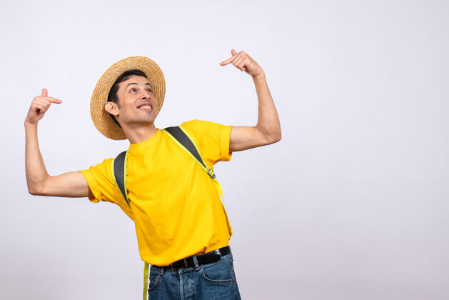 人正面图幸福的年轻人戴着帽子和黄色t恤指着自己帽子他自己成人