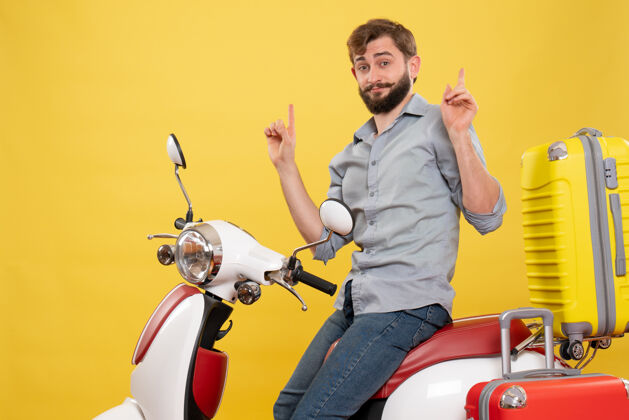 自行车旅游概念与年轻自信的胡须男子坐在摩托车上指着黄色传送带年轻人摩托车