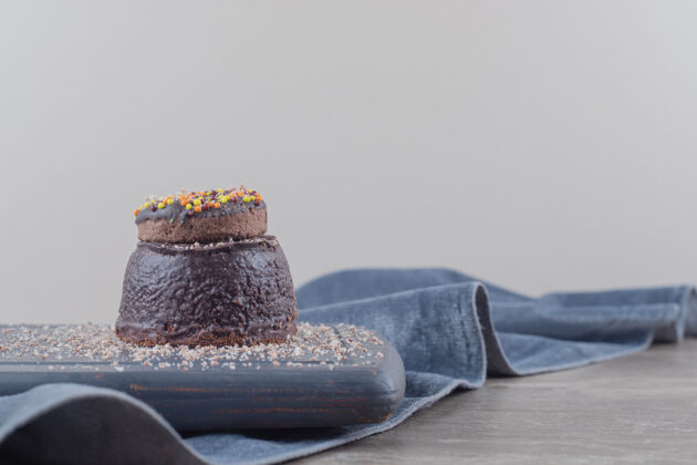 糕点小巧克力蛋糕上的甜甜圈放在大理石板上蛋糕美味美味