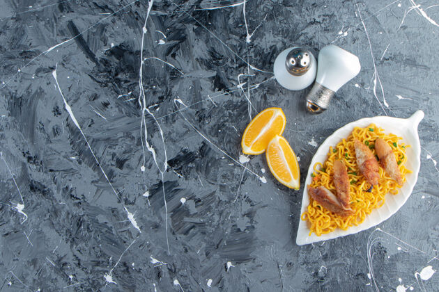 午餐盐 切成片的柠檬 放在盘子里的肉和面条旁边 放在大理石背景上意大利面一餐柠檬