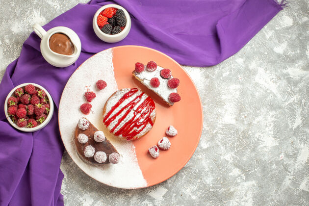 餐巾紫色餐巾上的甜点盘俯视图 大理石背景上有浆果和巧克力餐厅午餐早餐