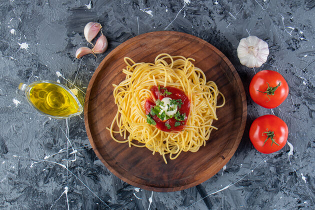 晚餐在大理石表面放上美味的意大利面和番茄酱和蔬菜食物大蒜午餐